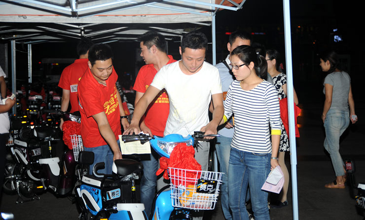 華億國(guó)際工作人員將電動(dòng)車(chē)交給顧客